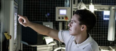 Man med kort mörkt hår som pekar på en dataskärm