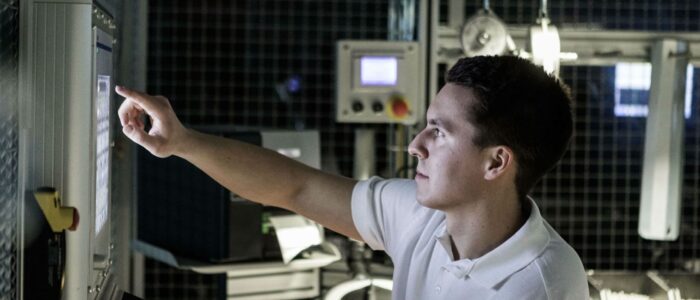 Man med kort mörkt hår som pekar på en dataskärm