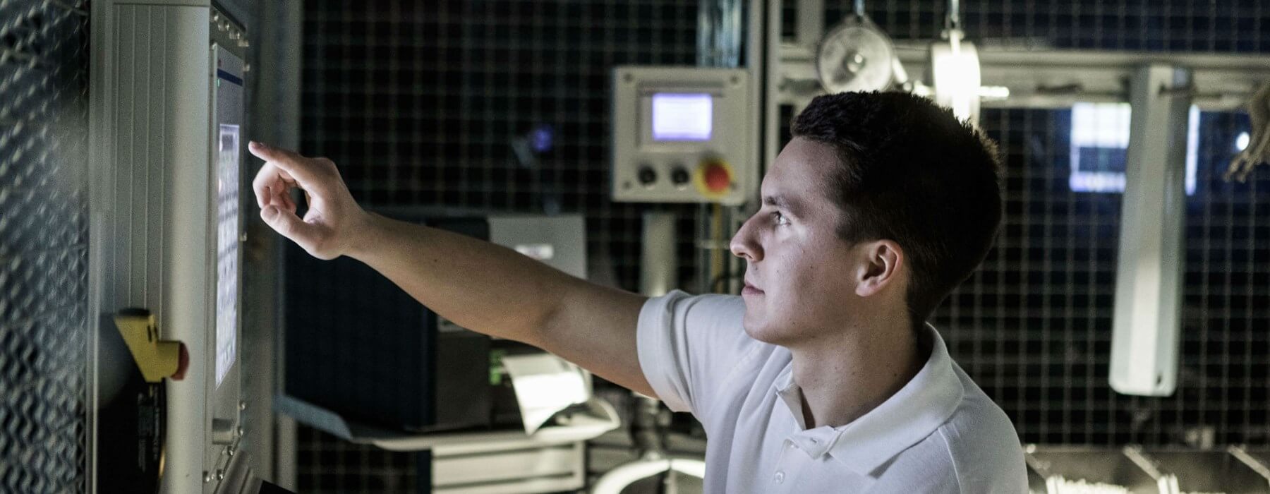 Man med kort mörkt hår som pekar på en dataskärm