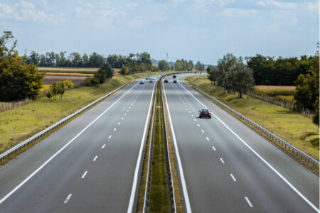 Två vägar med dubbelfiler i motsatt riktning mot varandra som sträcker sig rakt fram mot horisonten.