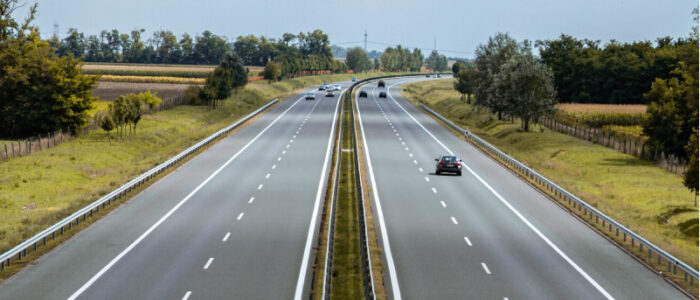 Två vägar med dubbelfiler i motsatt riktning mot varandra som sträcker sig rakt fram mot horisonten.