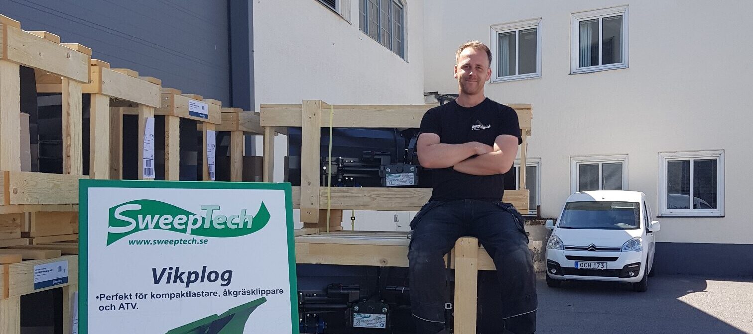 Man som sitter på EU-pallar bredvid en Sweeptech-skylt