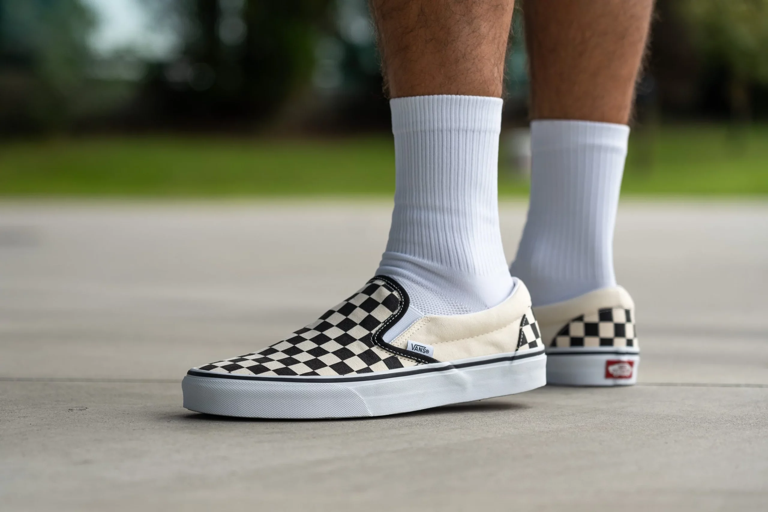 Zoomed in image of feet wearing checkered VANS sneakers.