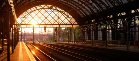 En tågstation fotad i solnedgång.