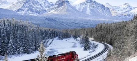 Ett frakttåg som kör bland snöiga berg.