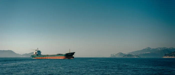 Ett fraktfartyg på öppet hav som ses på långt håll.