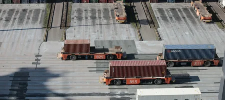 Lastbilar som står på en parkering i ett hamnområde.