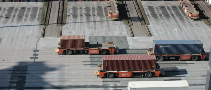 Lastbilar som står på en parkering i ett hamnområde.