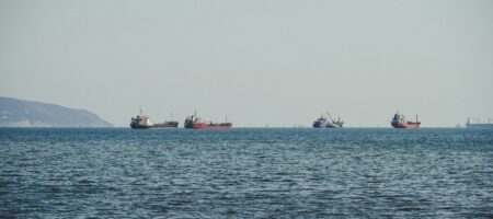 Flera fraktfartyg på öppet hav sett i fjärran.
